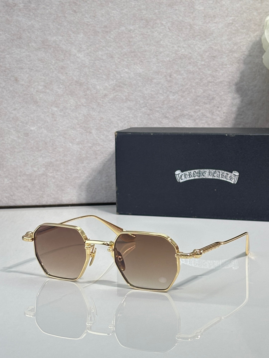Chrome sunglasses with brown lenses and gold-toned frame, front view