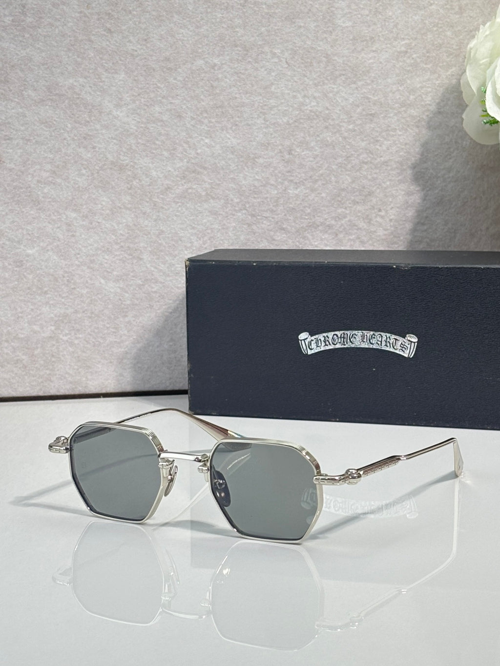 Chrome sunglasses with teal square lenses and silver frame, angled front view