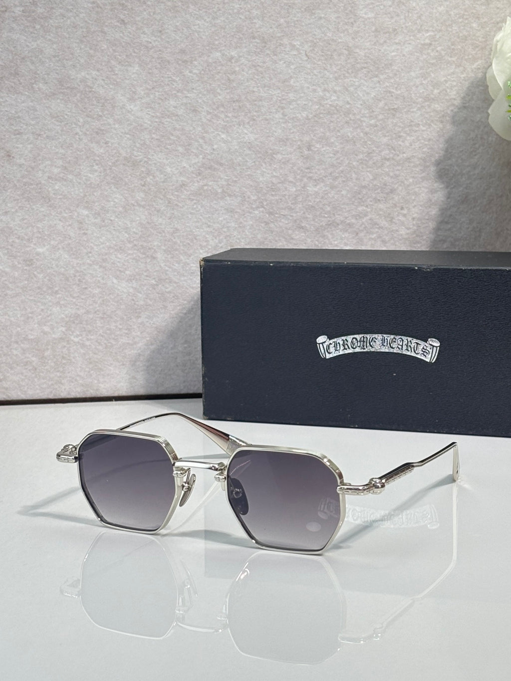 Chrome sunglasses with dark gray square lenses and silver frame, front view