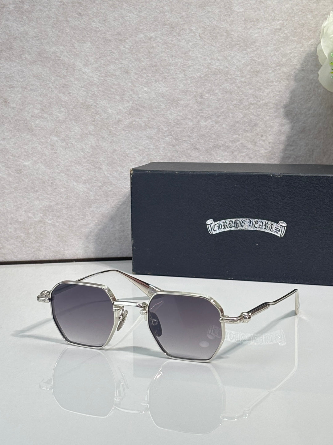 Chrome sunglasses with dark gray square lenses and silver frame, front view