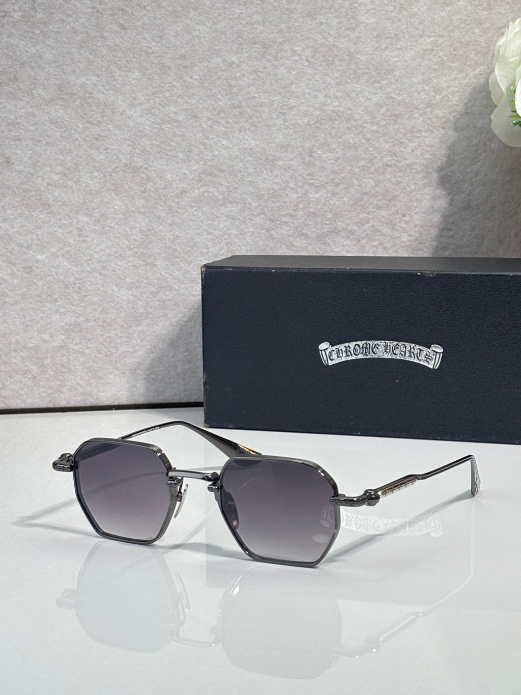 Chrome sunglasses with dark gray square lenses and silver frame, angled front view