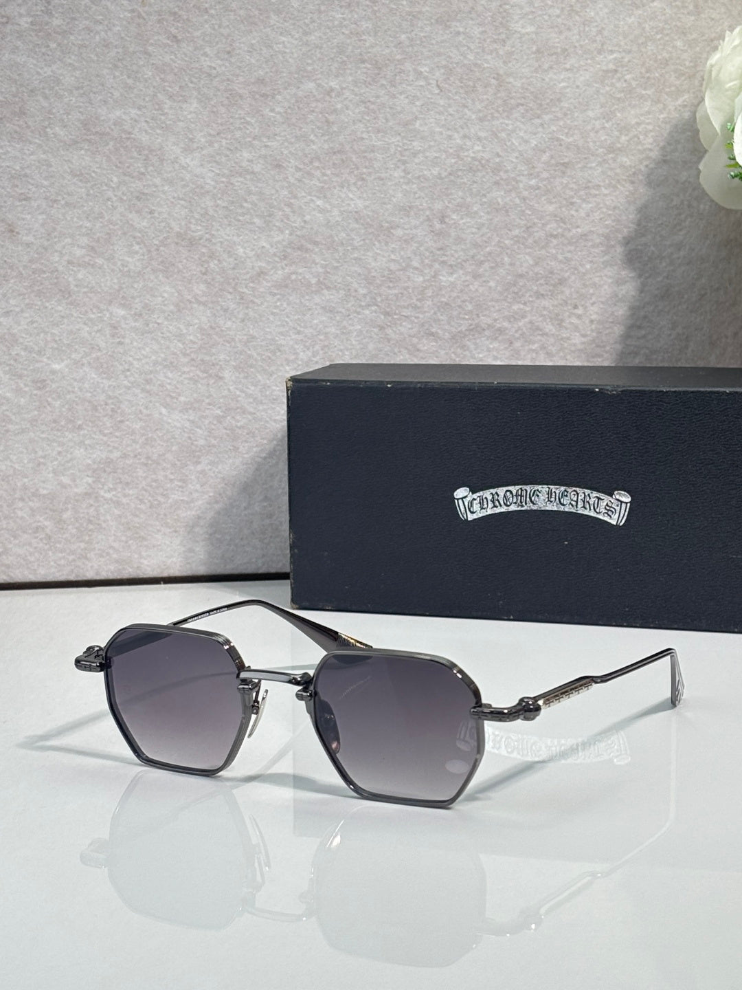Chrome sunglasses with dark gray square lenses and silver frame, angled front view