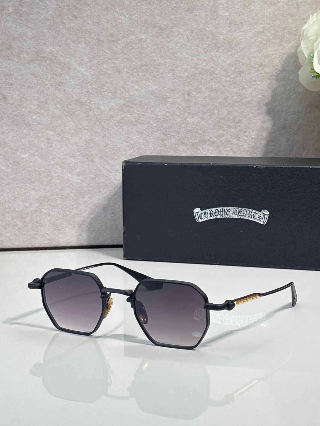 Chrome sunglasses with dark lenses and silver frame, side view