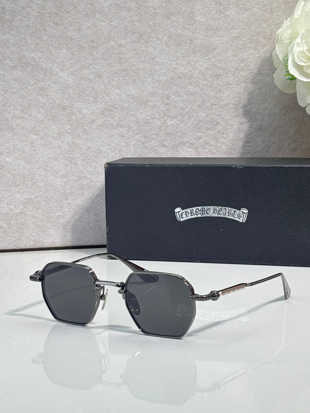 Chrome sunglasses with dark lenses and silver frame, side angle