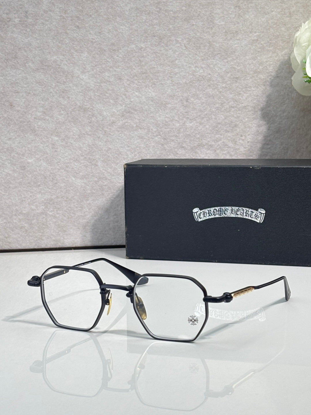 Black rectangular eyeglasses with clear lenses, gold-tone hinge details
