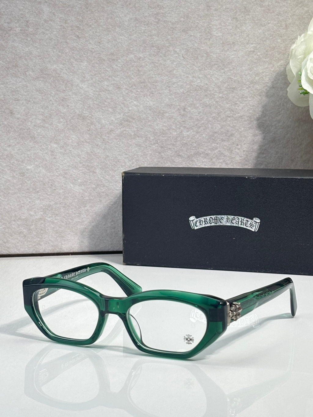 Chrome glasses with green frame, round-square clear lenses, and metal side accents.