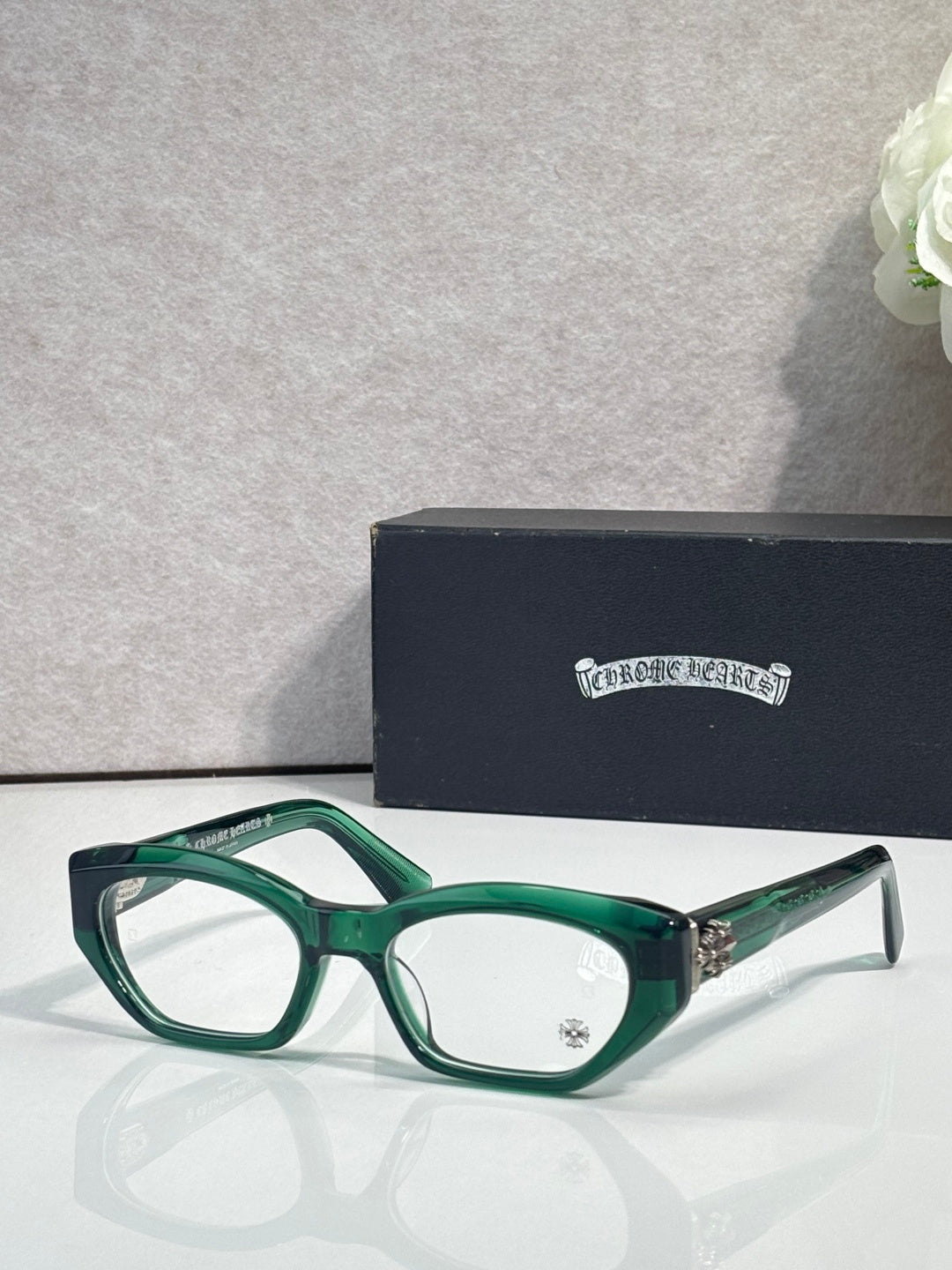 Chrome glasses with green frame, round-square clear lenses, and metal side accents.