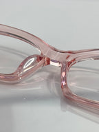 Chrome glasses close-up: pink translucent frame, curved bridge, clear lenses.