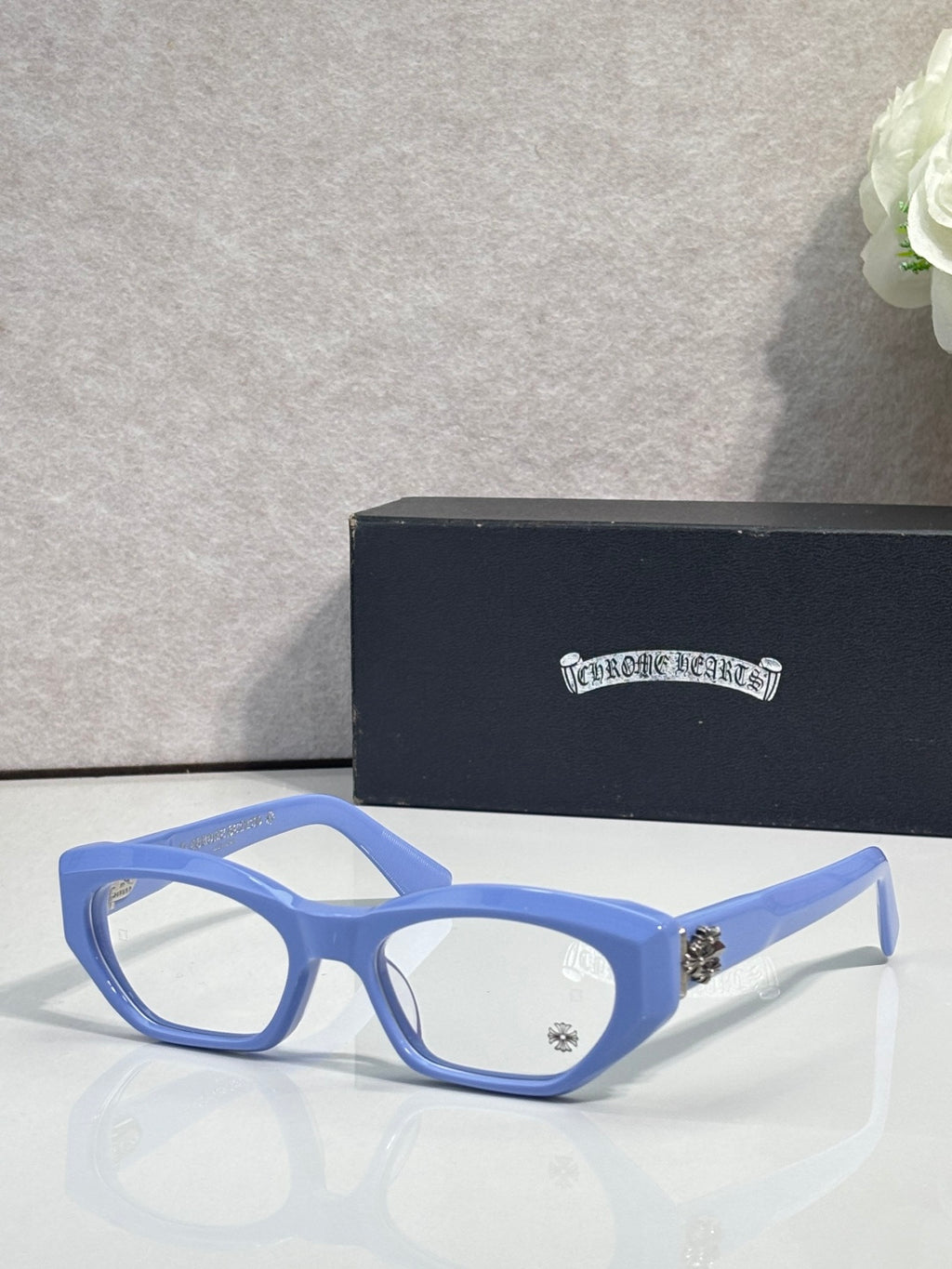 Chrome glasses with blue frame, round-square clear lenses, and metal side details.