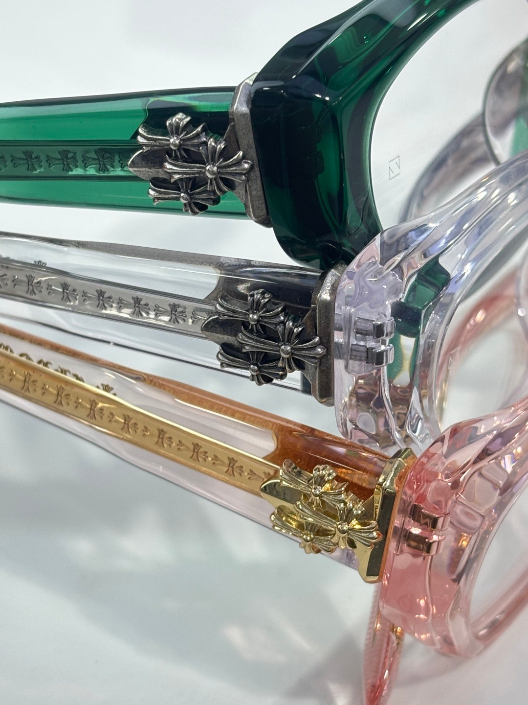 Chrome glasses close-up of temples and hinges with green and silver accents.