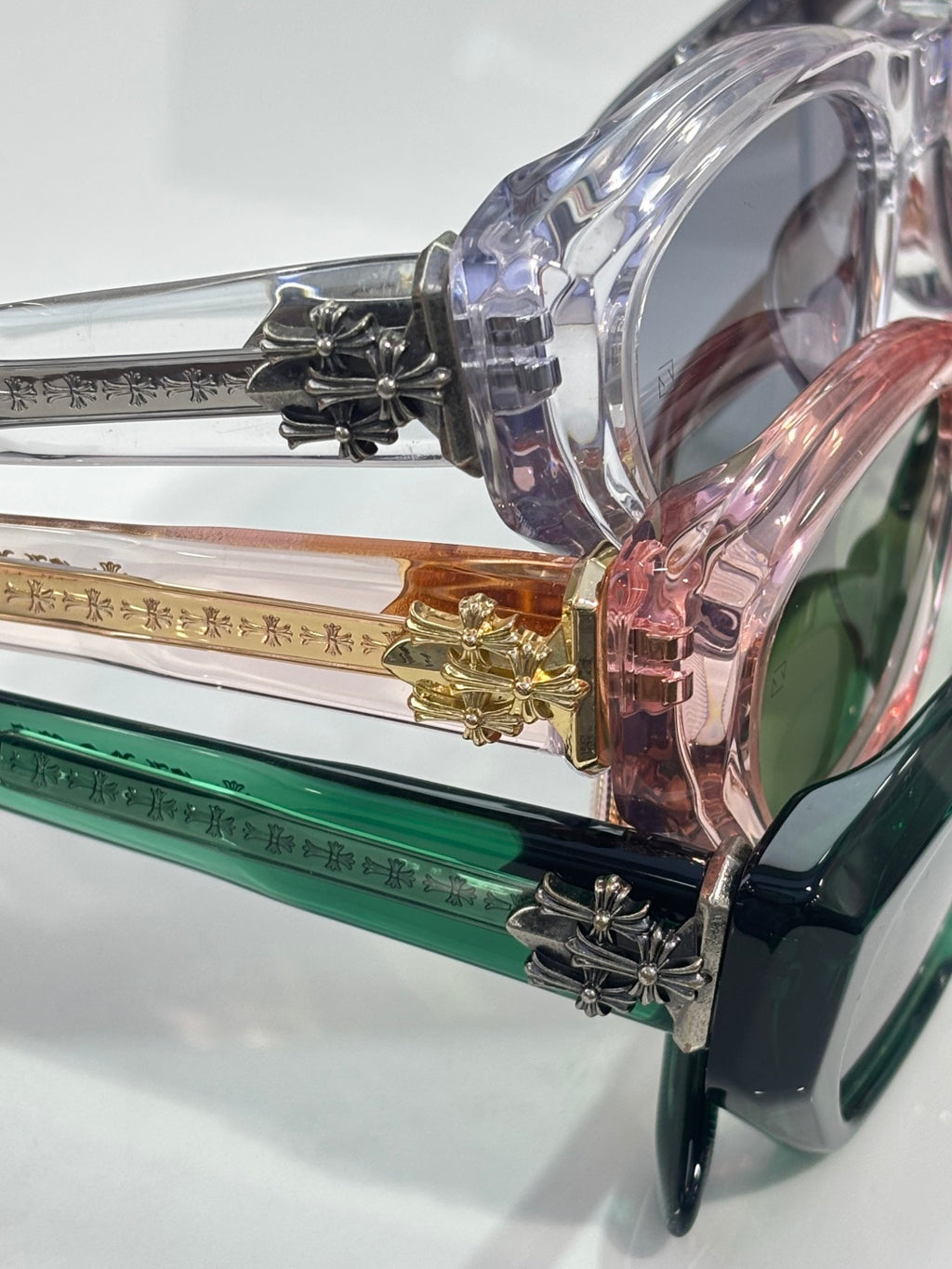 Assorted colored glasses frames stacked together, showing green and clear lenses