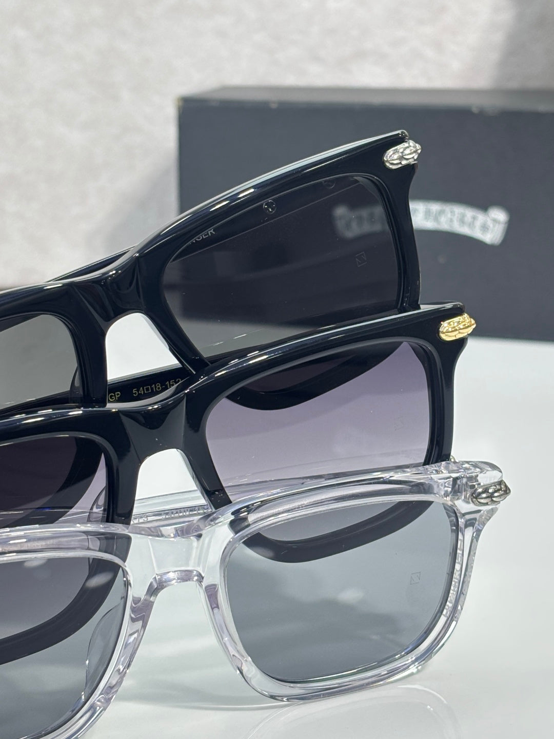 Eyeglasses close-up showing black and clear frames with gray-tinted lenses