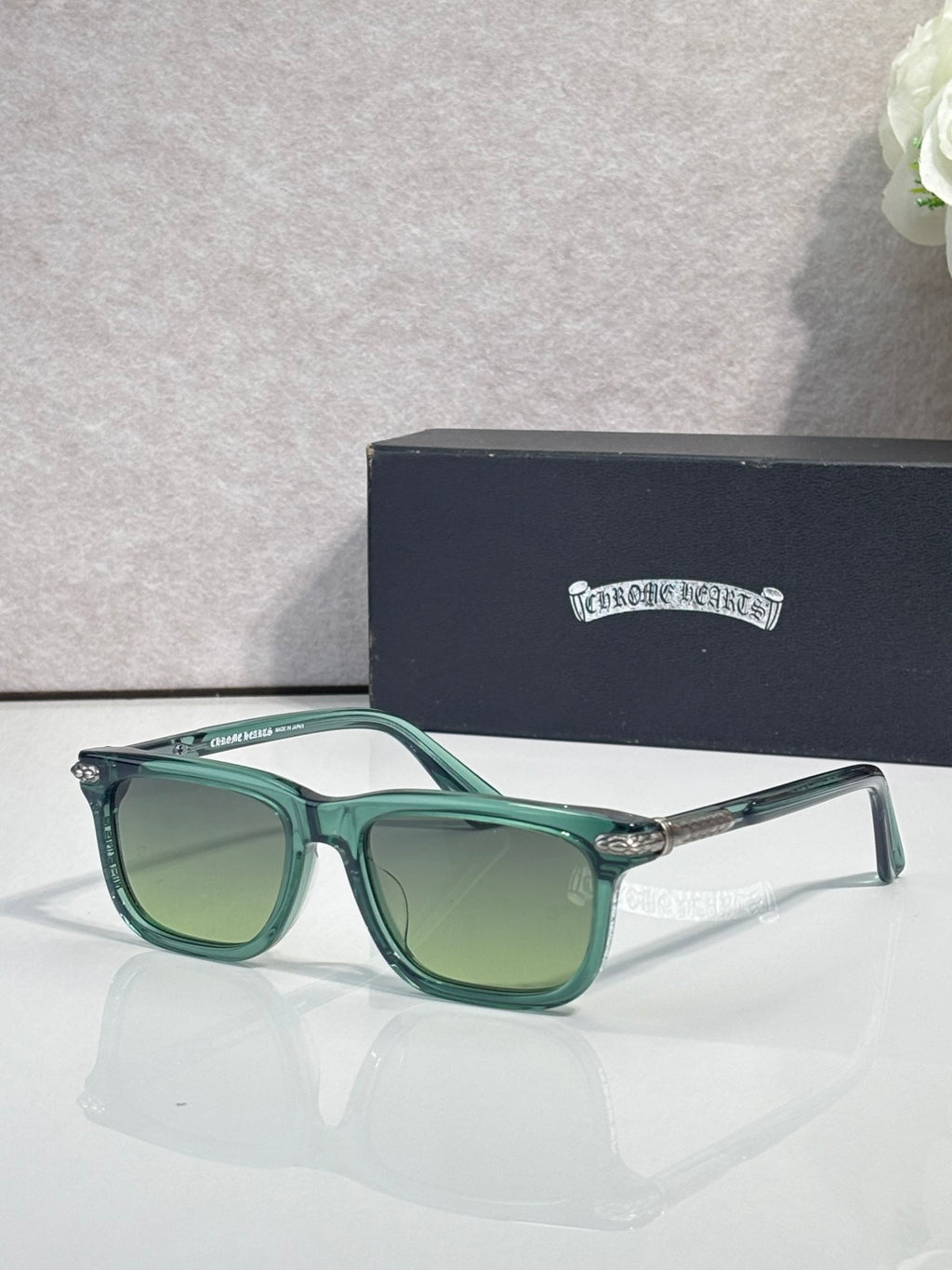 Teal eyeglasses with green-tinted lenses and rectangular frames