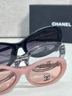 Chanel sunglasses close-up: dark frames over pink lenses; Chanel logo on temple