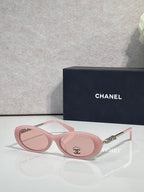 Chanel sunglasses with pink round frames and mirrored lenses; gold logo temple detail