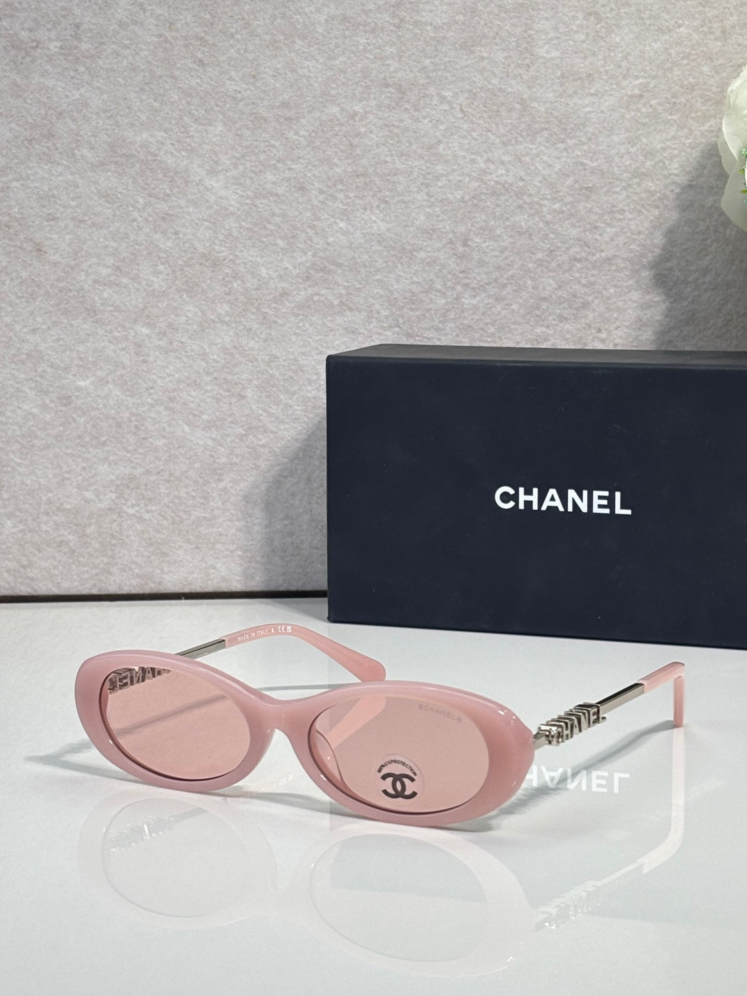Chanel sunglasses with pink round frames and mirrored lenses; gold logo temple detail