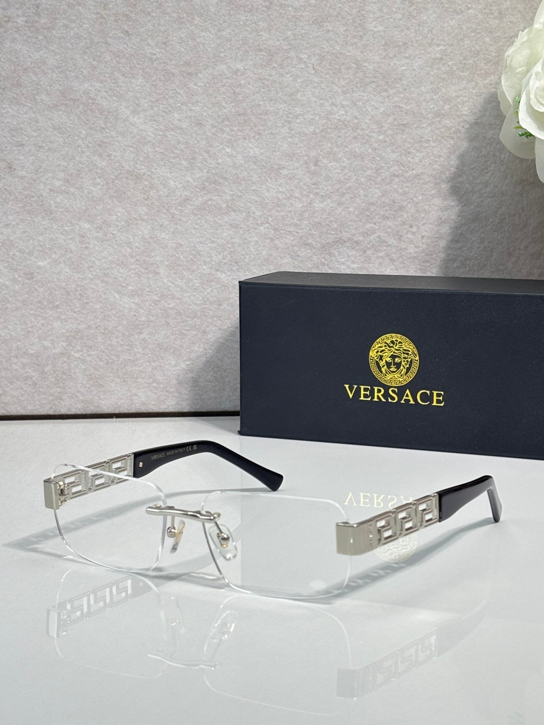 Versace glasses with clear lenses, dark frame, gold and silver geometric temple detail