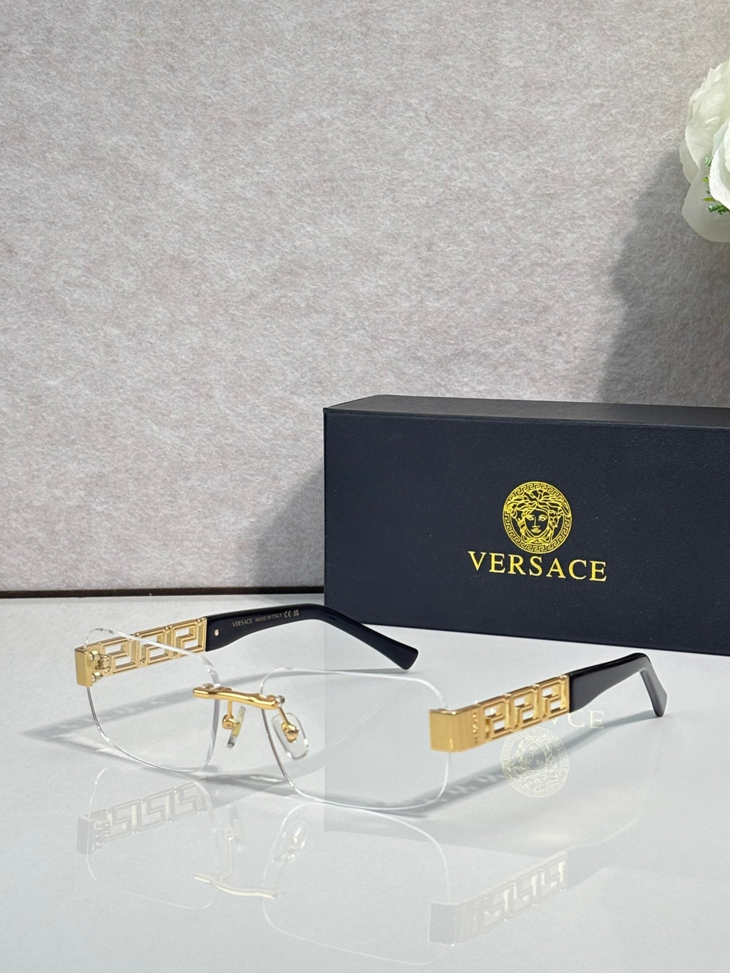 Versace glasses with clear lenses, dark frame, gold Medusa logo temple detail