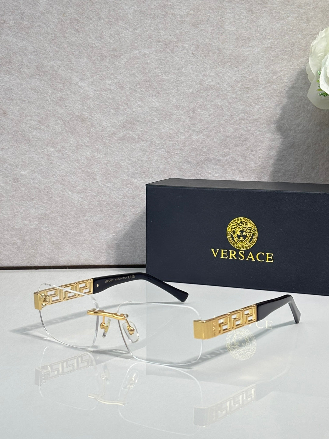 Versace glasses with clear lenses, dark frame, gold Medusa logo temple detail