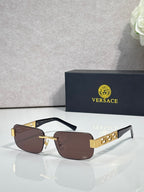 Black-frame sunglasses with brown tinted lenses and gold bar detail