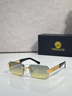 Gold-tone sunglasses with pale yellow tinted lenses and geometric logo temples