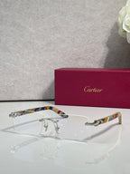 Cartier glasses with clear lenses, gold frame, and multicolor striped temples