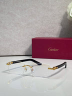 Cartier glasses with clear lenses, gold metal frame, and dark blue side accents