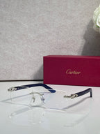 Cartier glasses with clear lenses, gold frame, and navy-blue temple panels