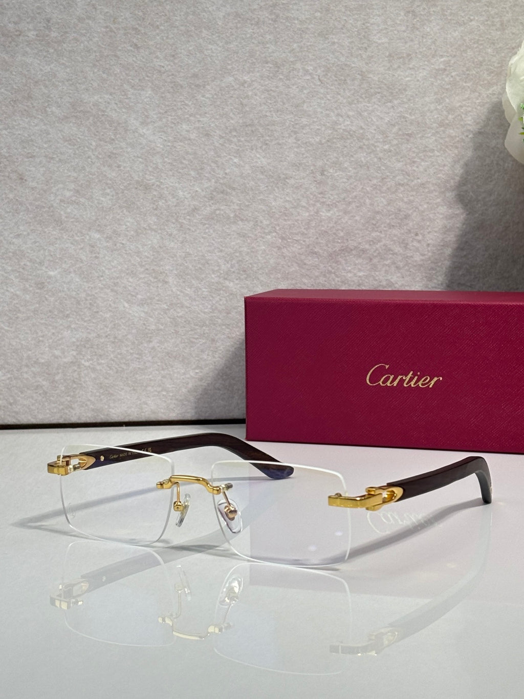 Cartier glasses with clear lenses and gold metal frame, dark blue temple tips