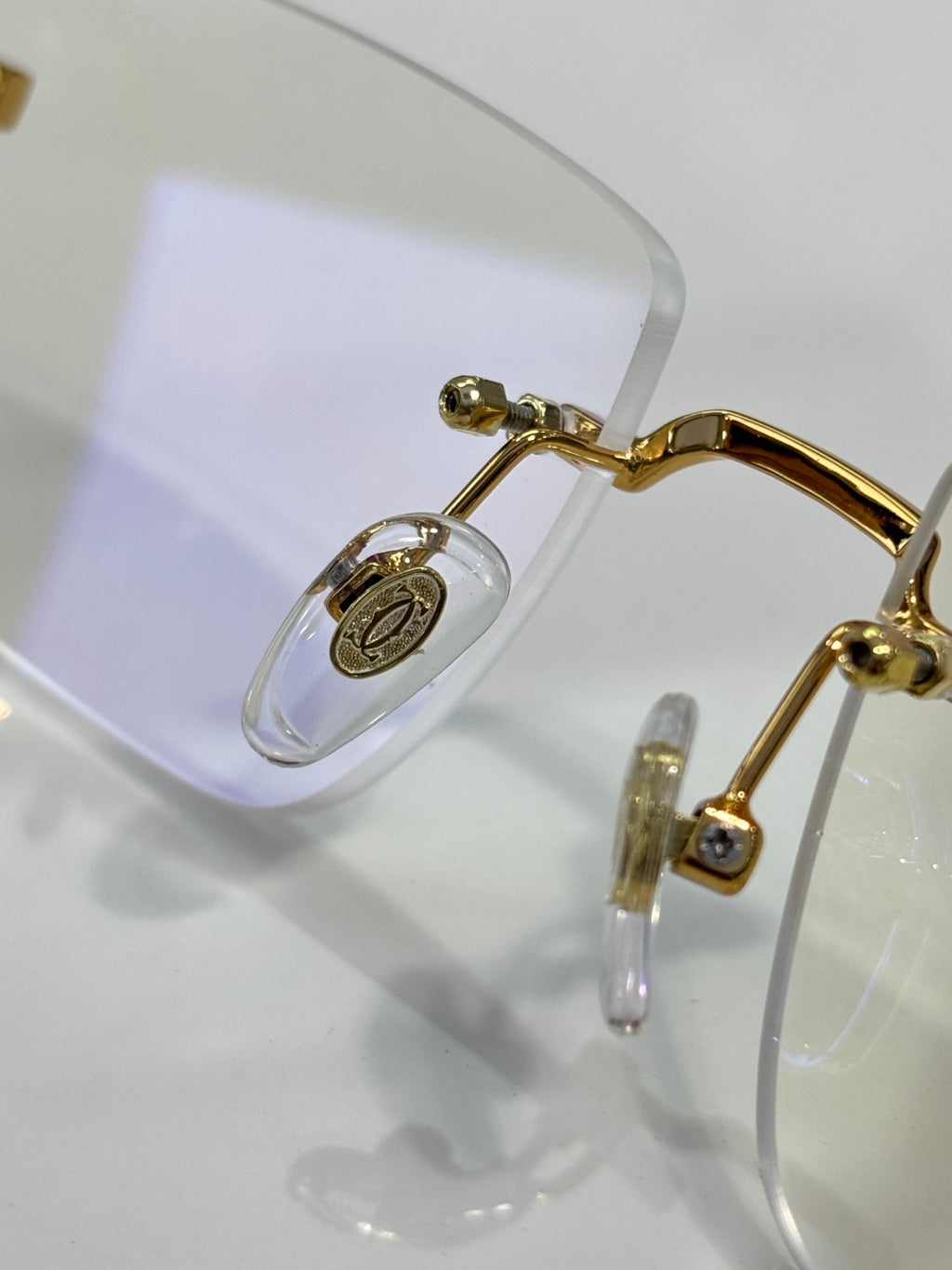 Cartier glasses close-up: gold hinge and clear temple with lens detail