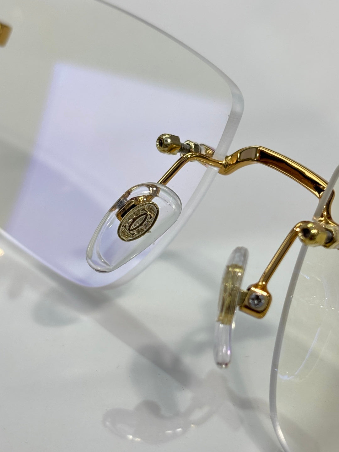 Cartier glasses close-up: gold hinge and clear temple with lens detail