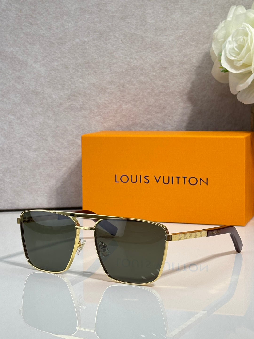 Louis Vuitton sunglasses with dark tinted lenses and black frame with gold-tone trim