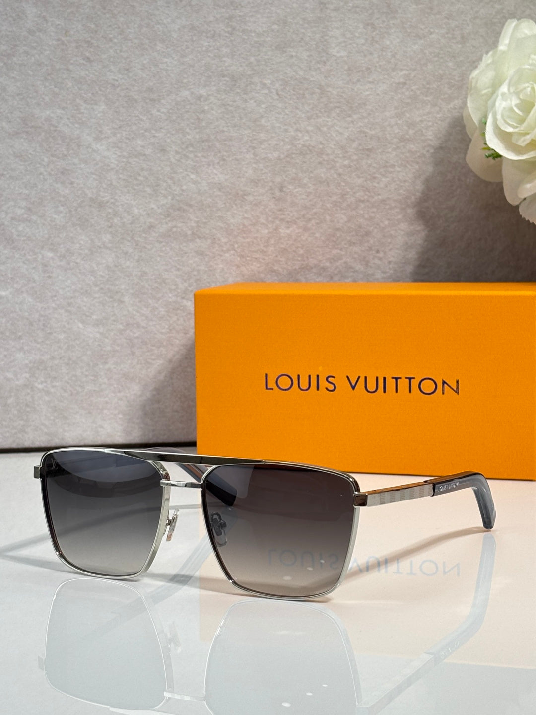 Louis Vuitton sunglasses with dark tinted lenses and gold-tone bridge detail