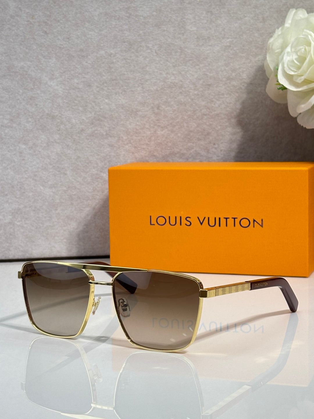 Louis Vuitton sunglasses with dark tinted lenses and gold-tone metal side arms