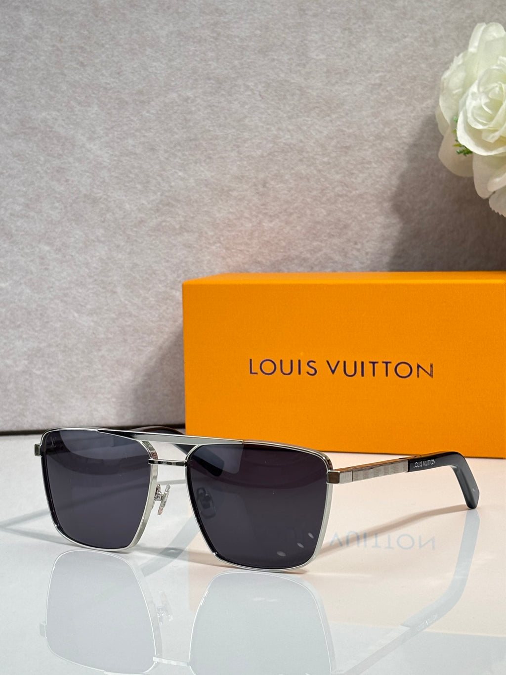 Louis Vuitton sunglasses with dark lenses, black frame, and gold-tone metal accents