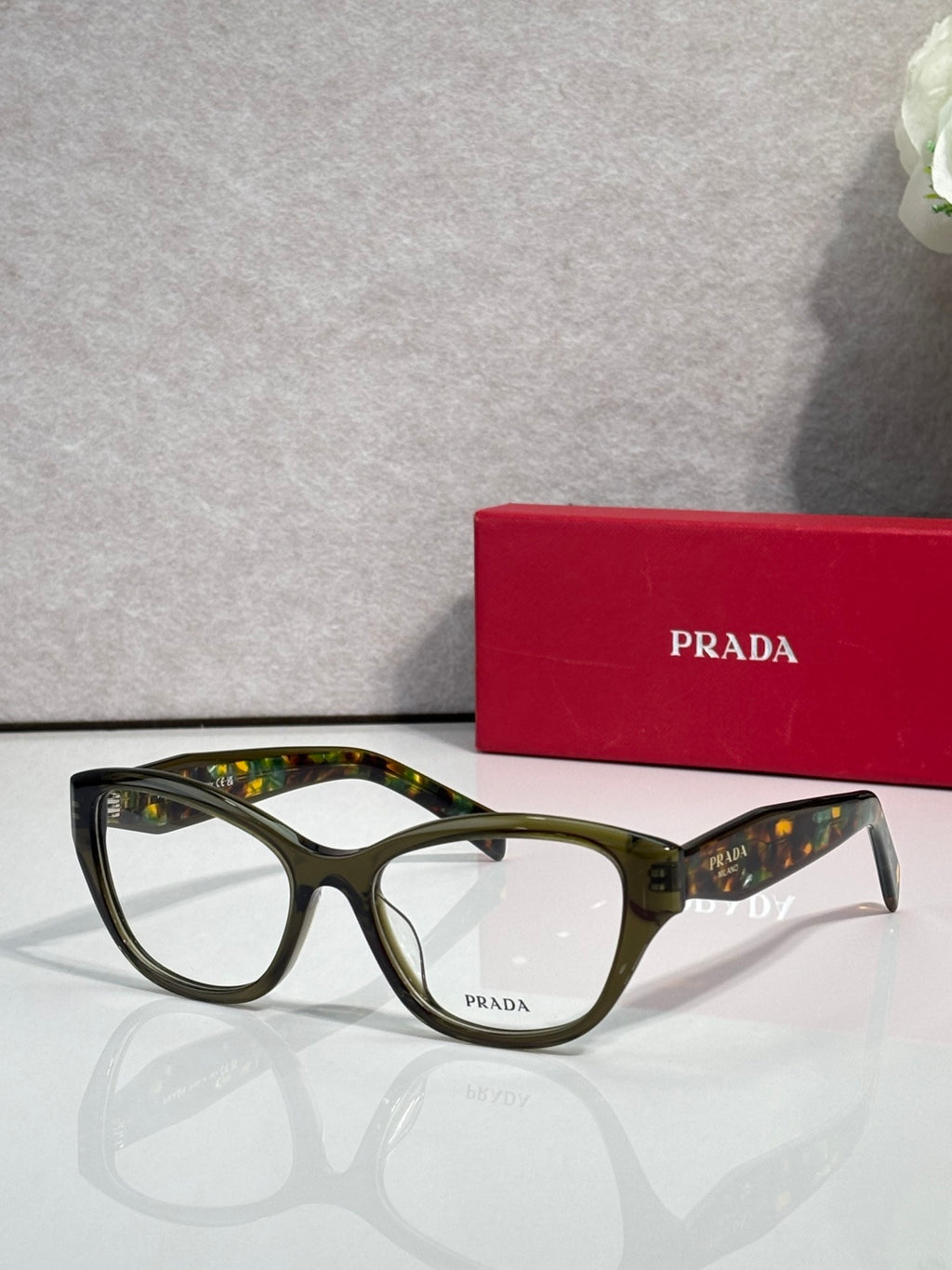 Prada dark green full-rim eyeglasses with clear lenses and curved acetate frame