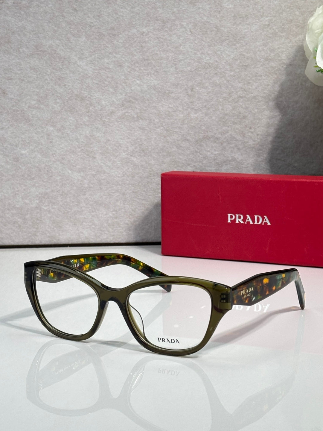 Prada dark green full-rim eyeglasses with clear lenses and curved acetate frame