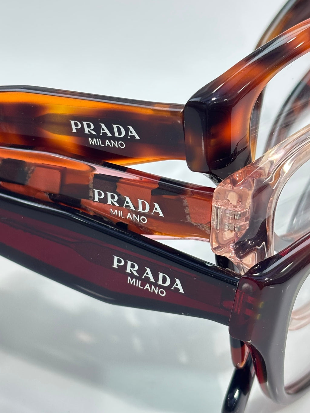 Prada Milano orange-brown eyeglasses close-up showing PRADA and Milano on frame