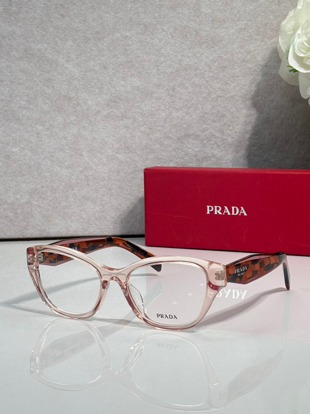 Prada light pink full-rim eyeglasses with clear lenses and glossy acetate frame