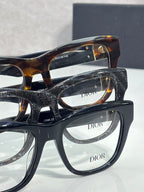 Stacked eyeglasses with navy frames and clear lenses, DIOR logos visible