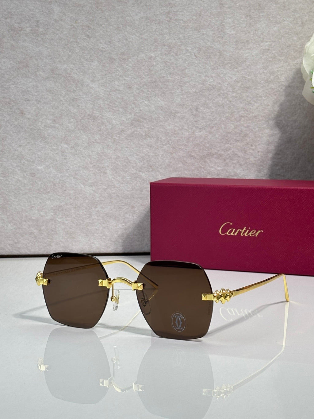 Gold metal-frame glasses with dark brown tinted lenses and decorative front connector