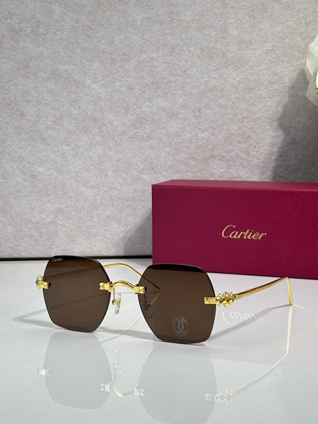 Gold metal-frame glasses with dark brown tinted lenses and decorative front connector