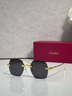Gold metal-frame glasses with dark lenses and decorative bow-style hinge detail