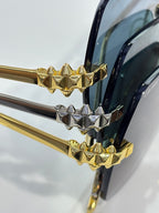 Close-up of gold-and-silver glasses temple joint with spiked geometric charms