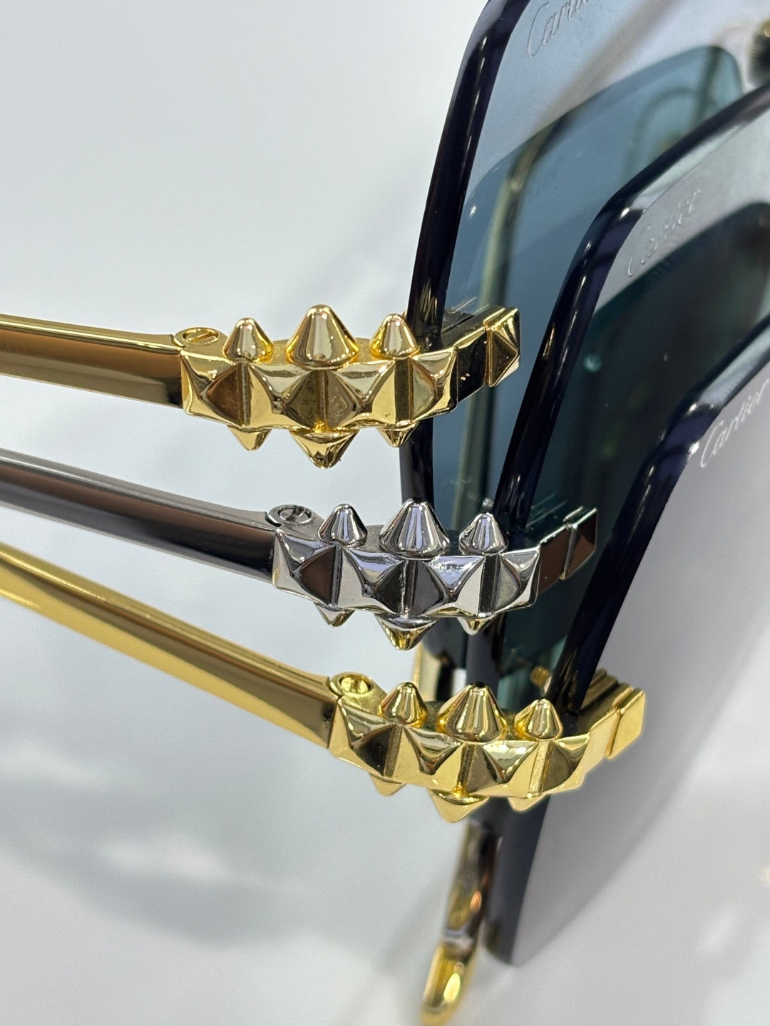 Close-up of gold-and-silver glasses temple joint with spiked geometric charms
