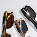 Prada sunglasses close-up: black and brown frames with mirrored lenses and gold trim