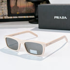 Prada sunglasses with light cream frame and blue-tinted lenses, metal temples with logo