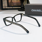 Black square eyeglasses with clear lenses and gold-toned chain trim