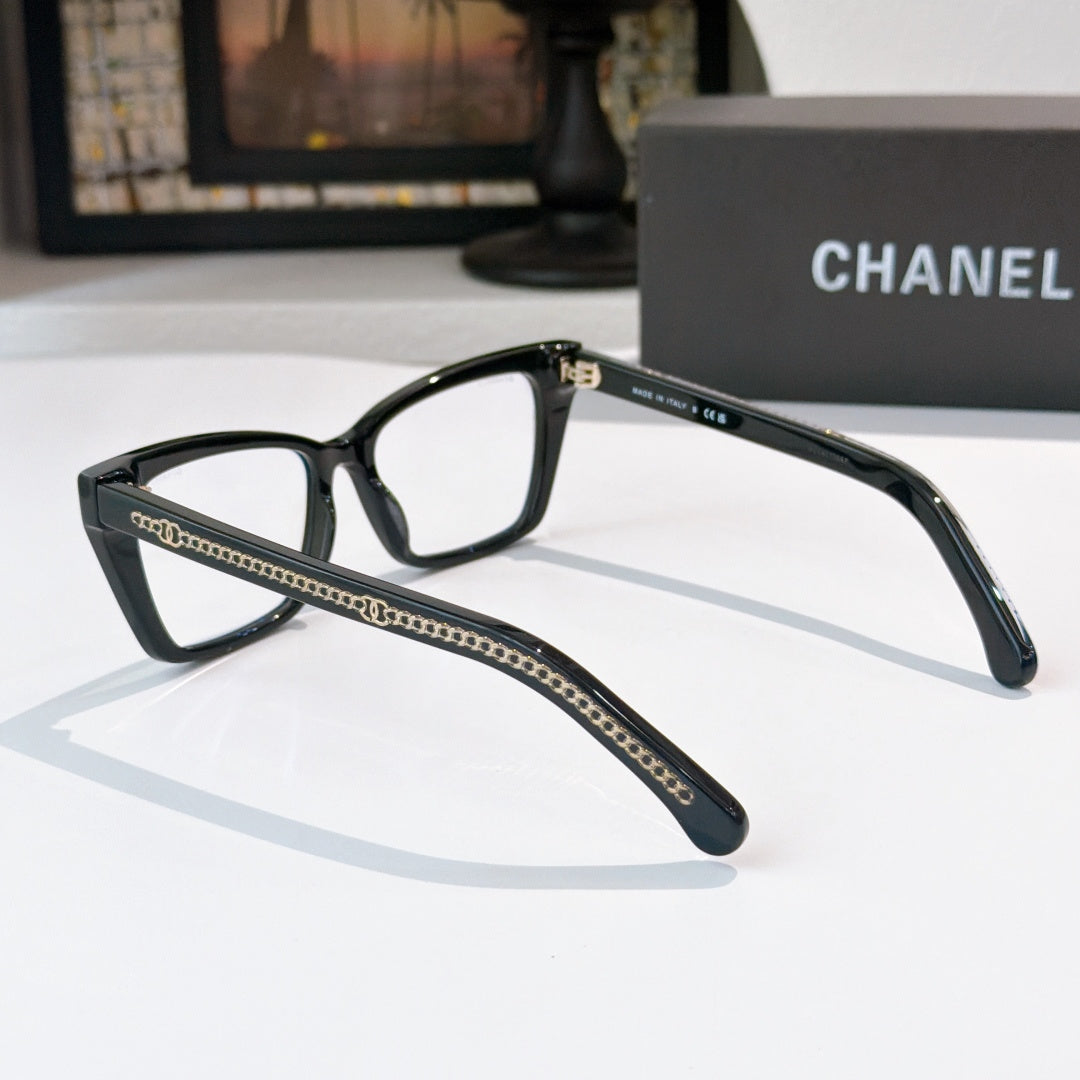 Black square eyeglasses with clear lenses and gold-toned chain trim