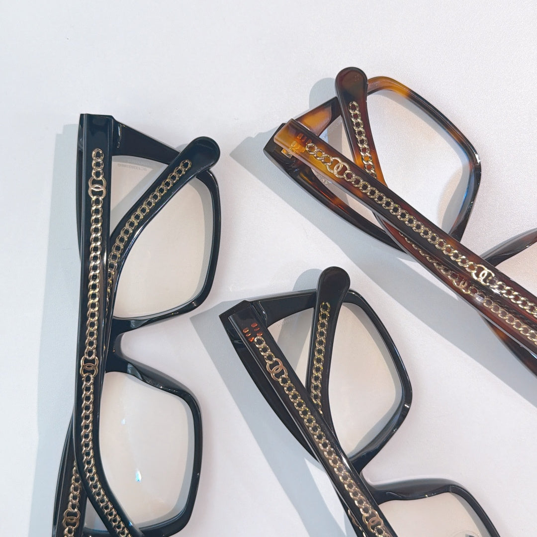 Set of three eyeglass frames: black, tortoiseshell, and dark blue with chain trim
